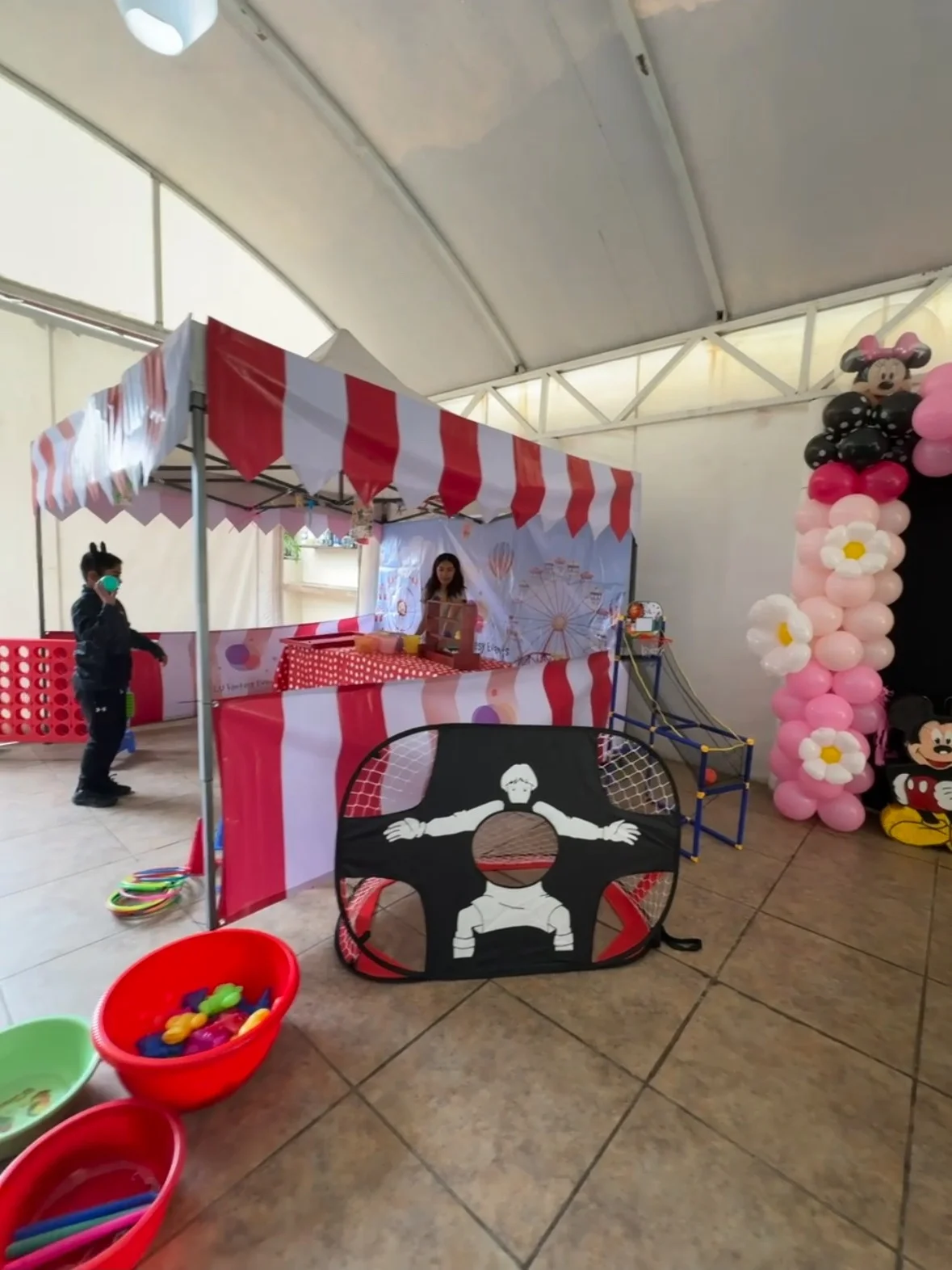Carpa y estaciones de juegos de Mini Feria en un salón de eventos