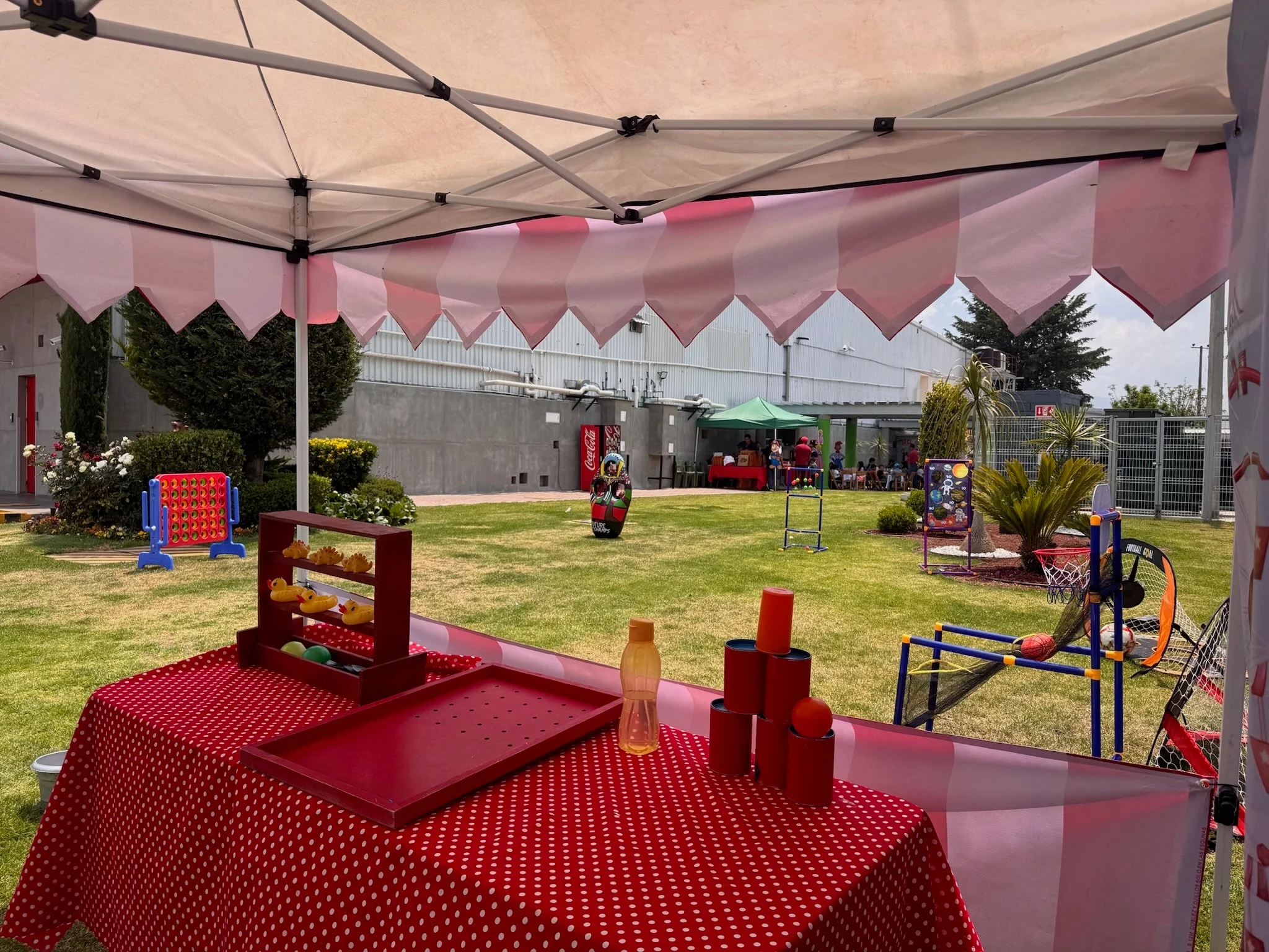 Juegos de Mini Feria bajo una carpa de rayas rojas y blancas