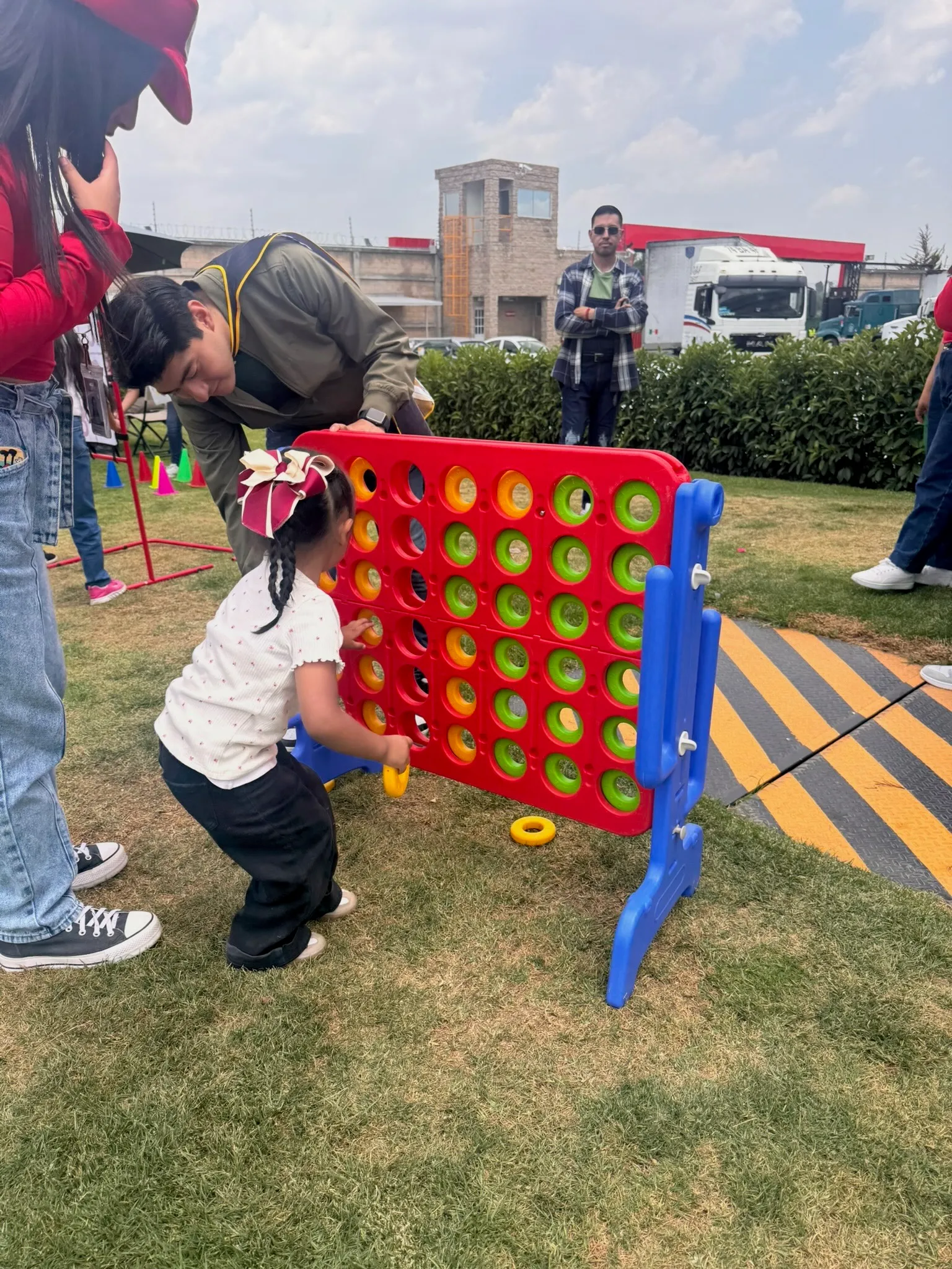 Una niña y un adulto jugando Conecta 4 en un evento de LU Fantasy
