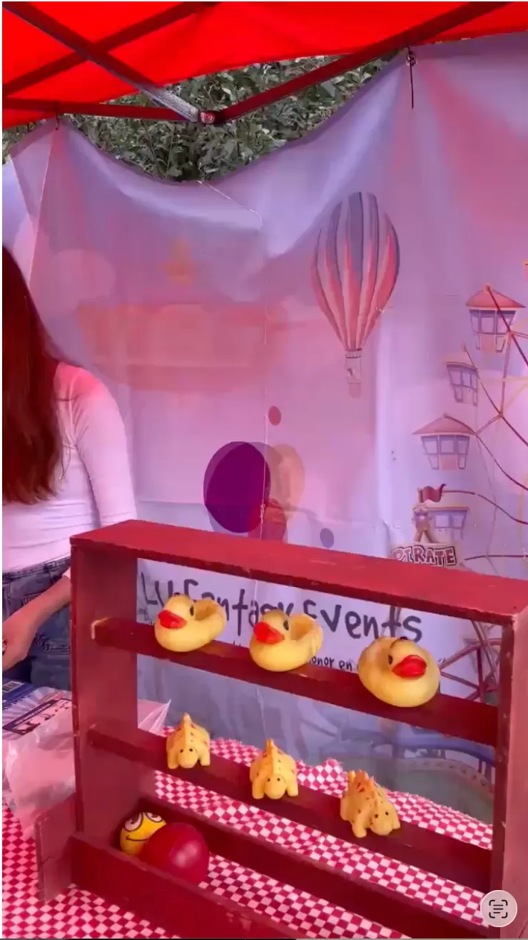 Estación de juego con patitos y pelotas bajo una carpa de LU Fantasy